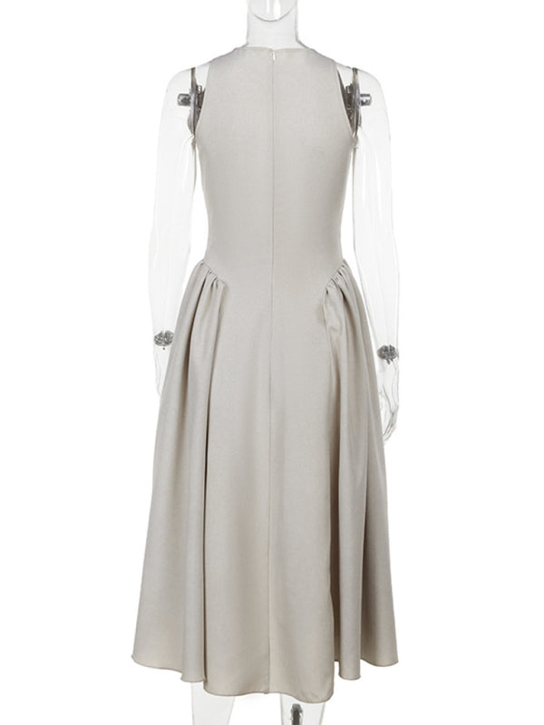 Mannequin displaying the back view of a beige sleeveless A-line dress with a keyhole neckline and a pleated skirt.