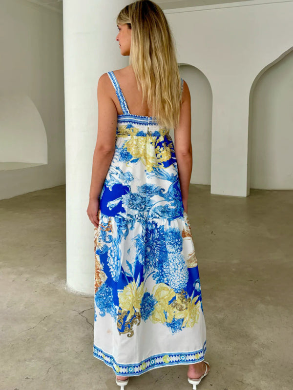Woman wearing a blue and white floral print maxi dress with spaghetti straps and a tiered skirt, viewed from the back.