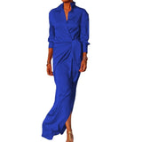 Woman wearing a long blue satin dress with a V-neck and long sleeves.