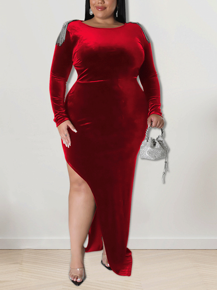 Woman wearing a floor-length red velvet dress with a high slit and embellished shoulders.