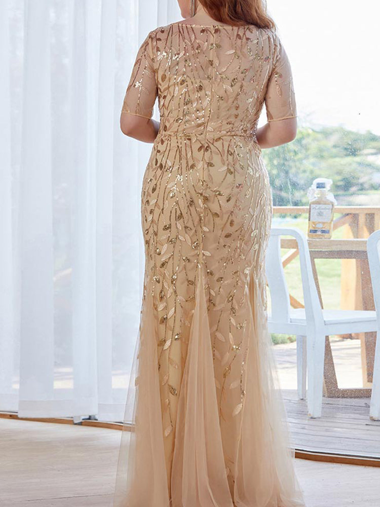 Back view of a woman in a gold sequined mermaid gown.