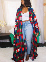 Woman wearing a long plaid maxi dress with a white crop top and light wash jeans