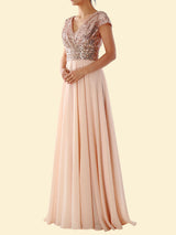 Woman wearing a blush pink sequined formal dress with a flowing skirt