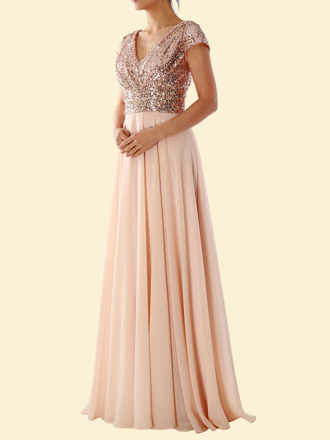 Woman wearing a blush pink sequined formal dress with a flowing skirt