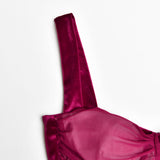 close-up of a spaghetti strap on a burgundy ruched velvet and mesh dress