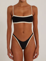 woman wearing a black and cream bikini set, front view