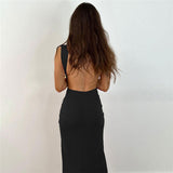 Back view of a woman in a black sleeveless maxi dress with an open back