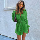 woman wearing a green pleated shirt dress with a belt