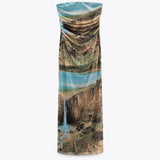 A strapless, full-length dress with a landscape print displayed flat against a white background.