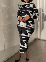 woman wearing a black and white abstract print long sleeve mock neck midi dress