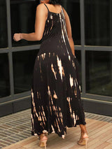Back view of a woman in a black and white tie-dye maxi dress, showing the asymmetrical hem.