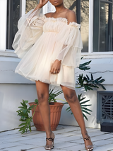woman wearing an off-the-shoulder ivory tulle dress with tiered bell sleeves