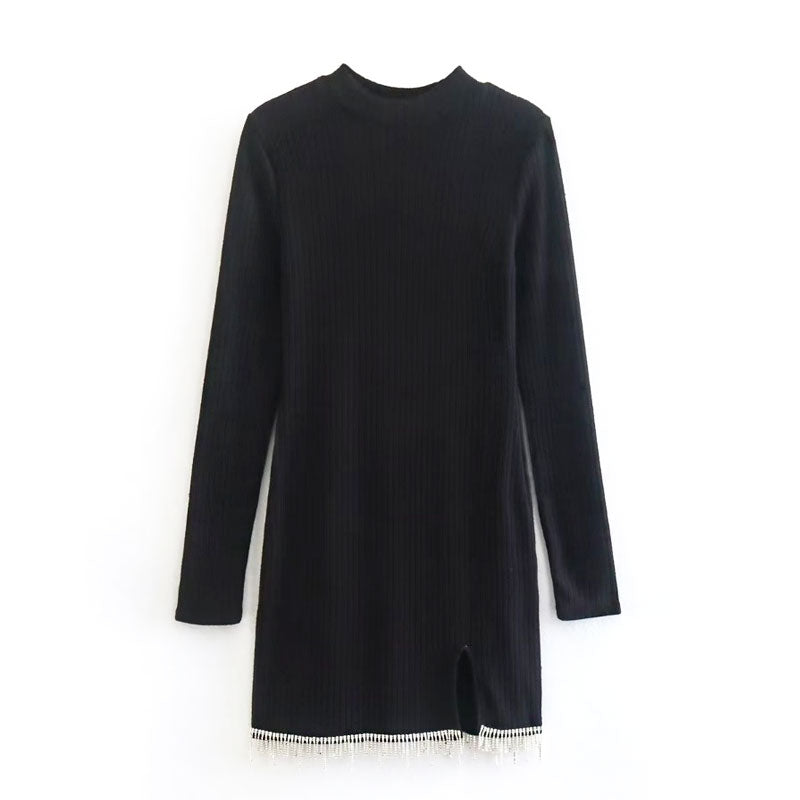 black long-sleeved dress with high neckline, side slit, and beaded trim displayed flat