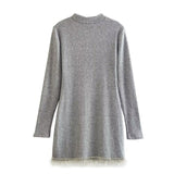 Back view of a grey ribbed knit mini dress with long sleeves and rhinestone trim hem.