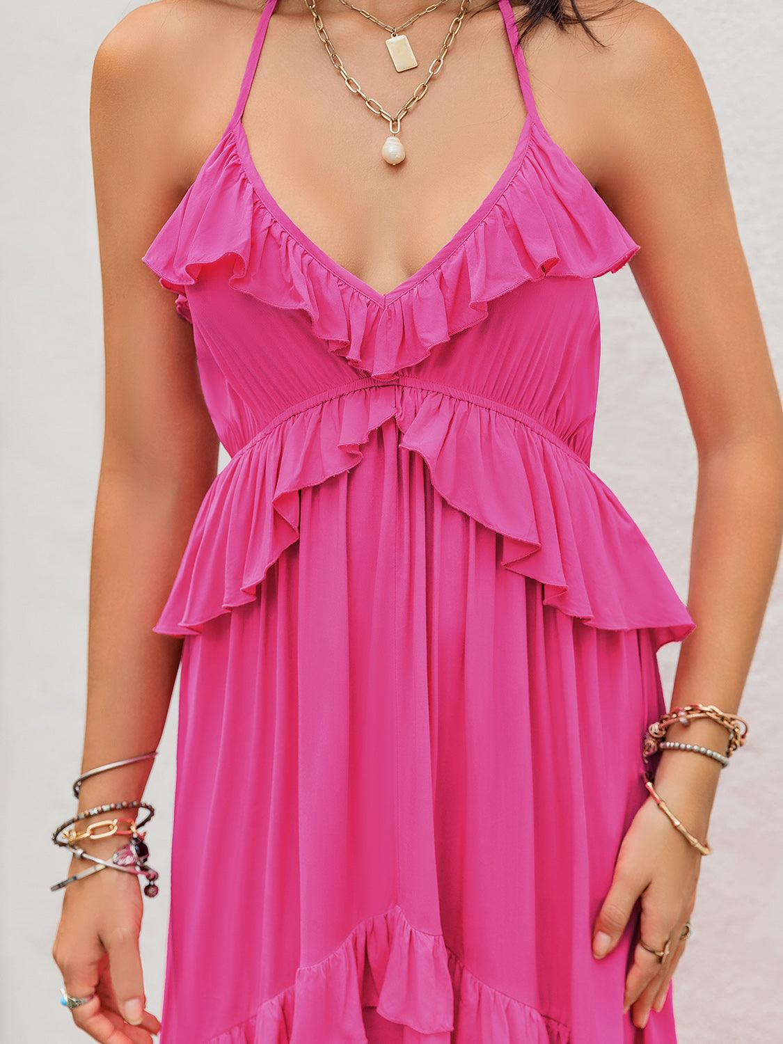 Close-up of the bodice of a pink tiered maxi dress with ruffle trim and layered necklaces.