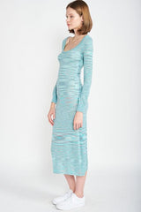 Side view of a woman wearing a long-sleeved, scoop-neck, midi-length, bodycon dress with a striped pattern in shades of blue and grey, paired with white sneakers.