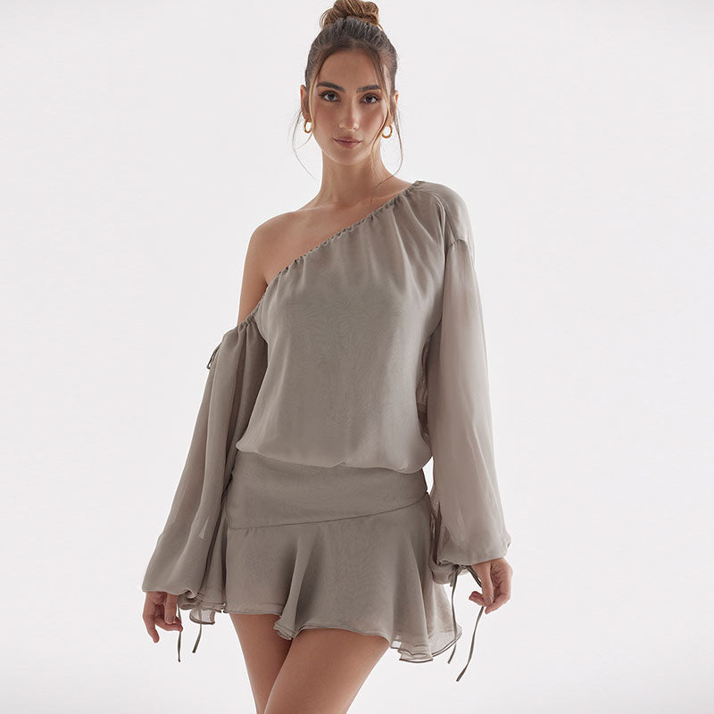 Model wearing a one-shoulder grey chiffon mini dress with long puff sleeves and a ruffled skirt.