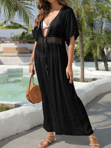 Woman wearing a black maxi cover-up with lace trim and a high slit