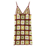 Close-up of the crochet pattern on the dress, showing square motifs in various shades of yellow, green, and white, bordered by brown.