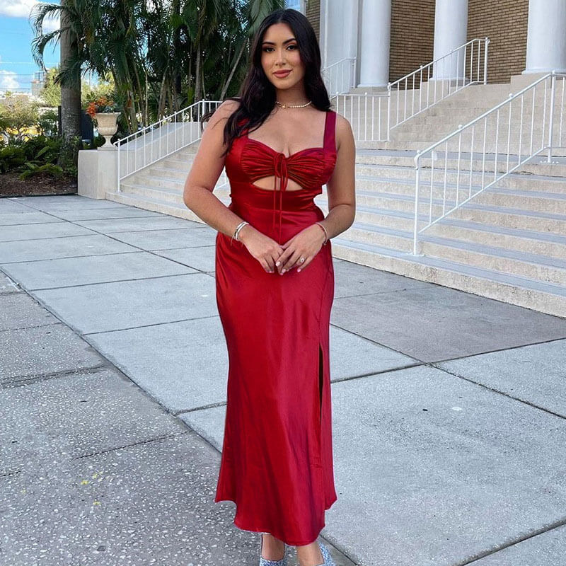 woman wearing a red satin slip dress with a cutout and thigh-high slit