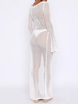 Back view of a woman wearing a white sheer knit maxi dress with a hood and high slit.