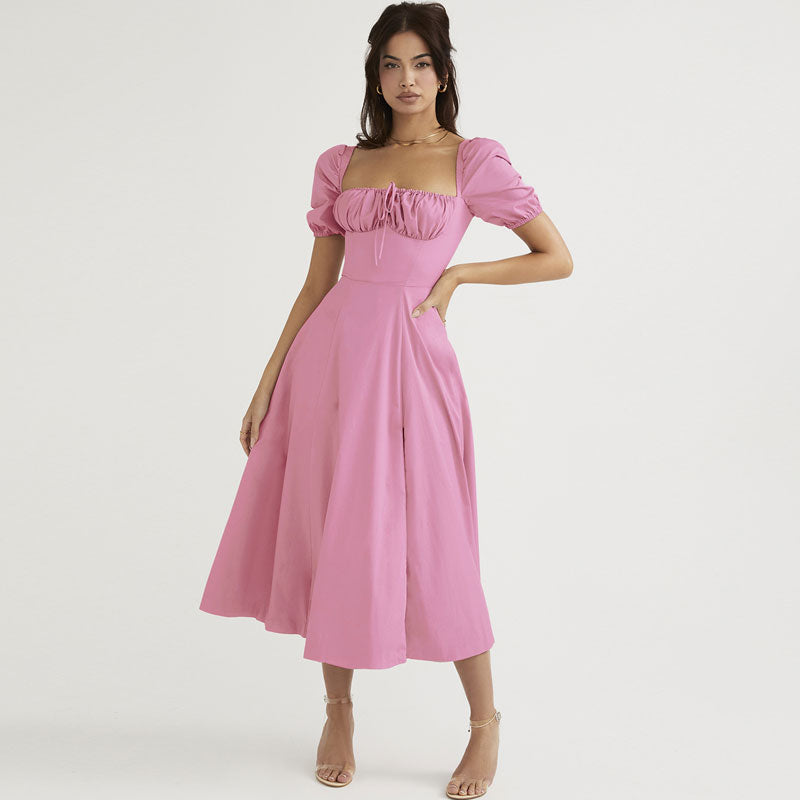 Woman wearing a pink midi dress with puff sleeves and a square neckline, standing against a white background.