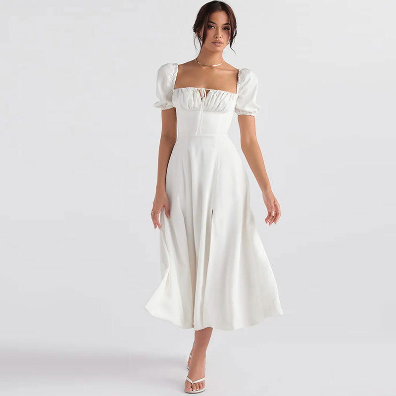 Woman wearing a white midi dress with puff sleeves and a square neckline.