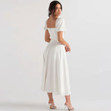 Back view of a woman in a white midi dress with puff sleeves.