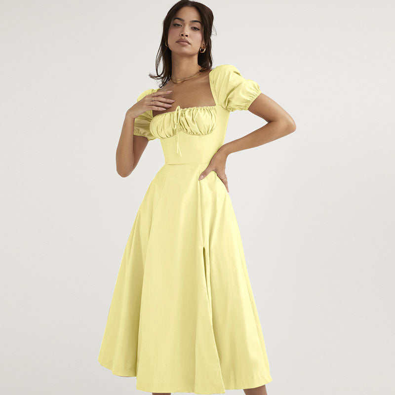Woman in a yellow square neck puff sleeve midi dress with a drawstring bust and a high slit.