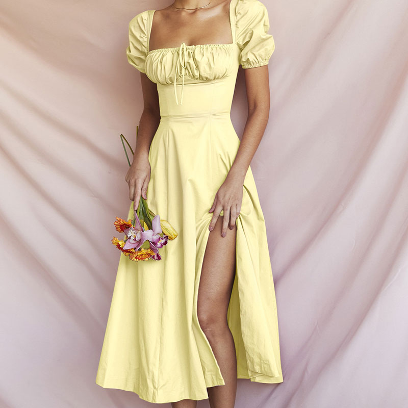 Model wearing a yellow puff sleeve midi dress with a drawstring detail and a side slit.