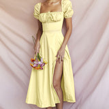 Model wearing a yellow puff sleeve midi dress with a drawstring detail and a side slit.