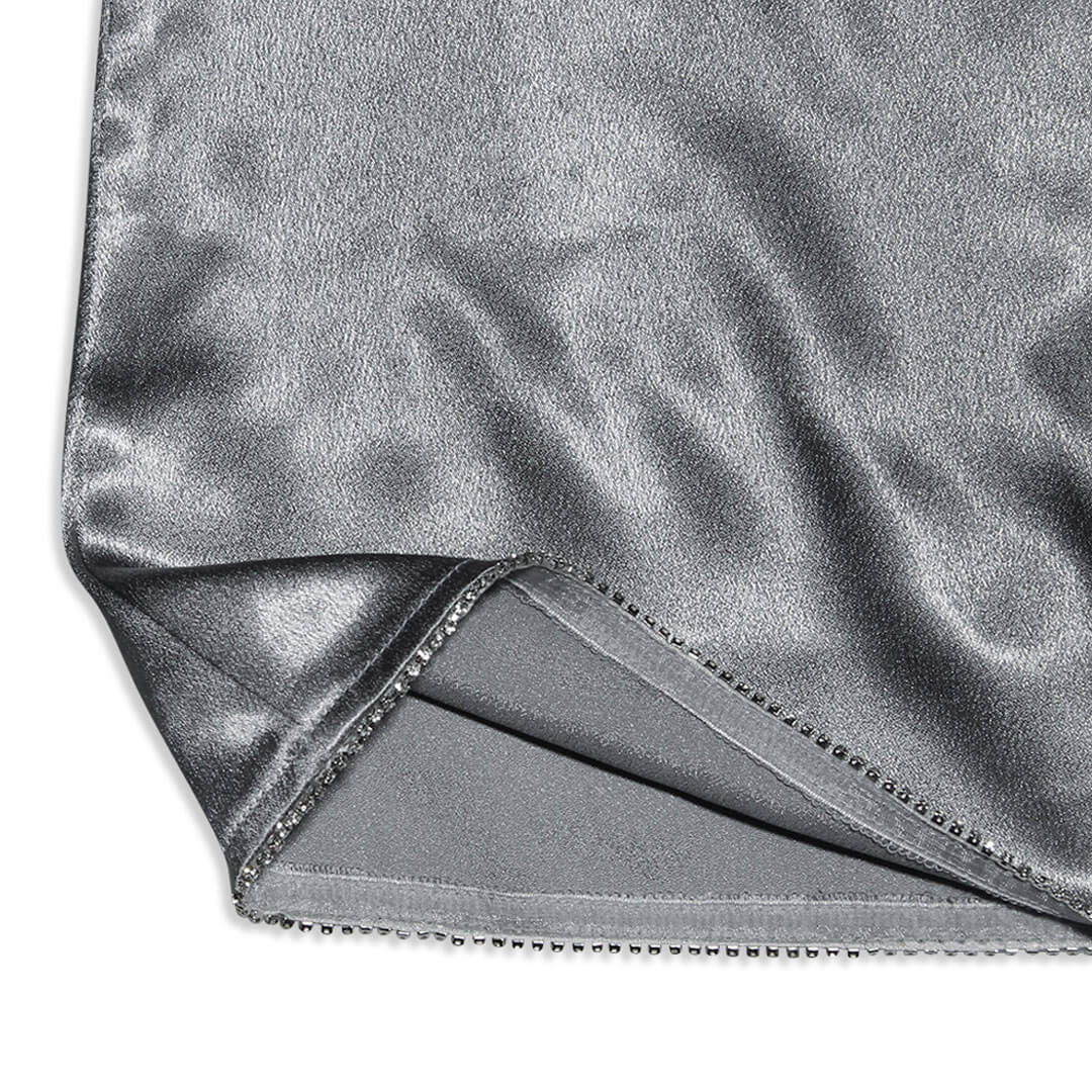 Close-up of the hem of a silver metallic dress, highlighting the sparkling trim and fabric texture.