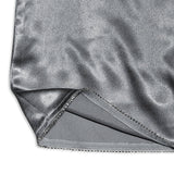 Close-up of the hem of a silver metallic dress, highlighting the sparkling trim and fabric texture.