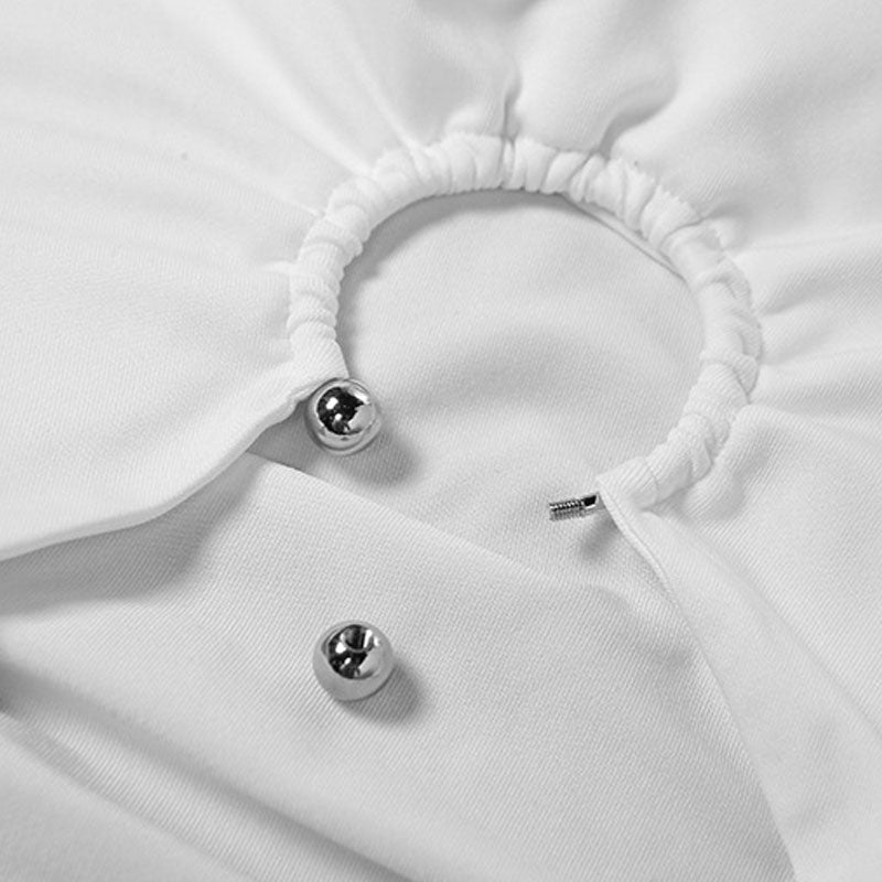 Close-up of the neckline of a white ruched halter mini dress showing ring embellishments