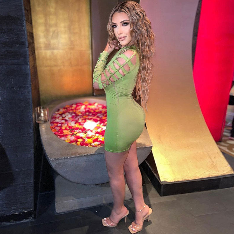 woman posing in a green cut-out sleeve dress