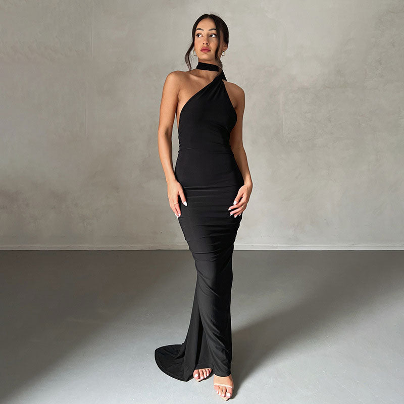 woman wearing a black one-shoulder halter neck maxi dress with a draped train