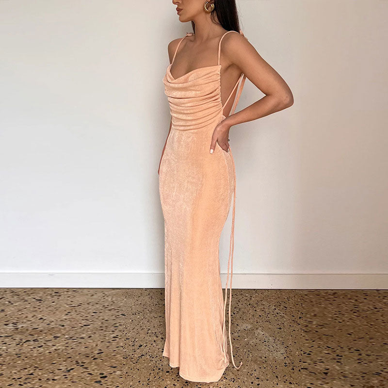full body shot of a woman in a peach velvet maxi dress