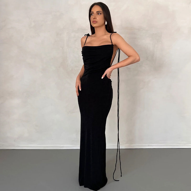 woman wearing a long black dress with tie straps and a cowl neck