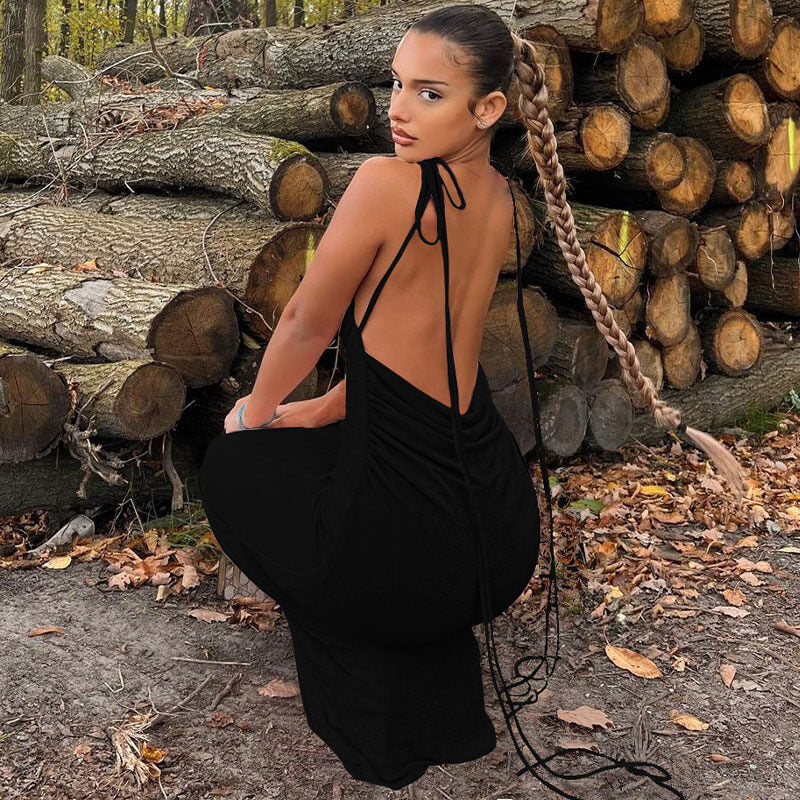 woman in a long black ruched dress with tie straps in an outdoor setting