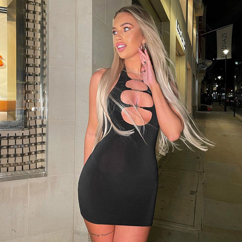 woman wearing a black mini dress with cut-out details and chain embellishments