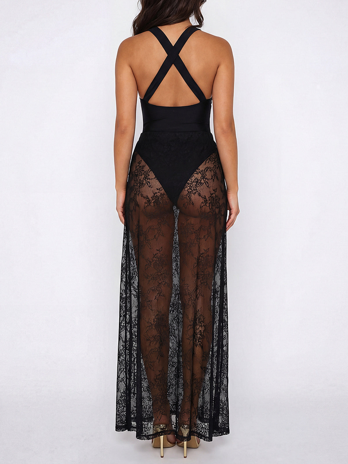 Woman wearing a black maxi dress with a sheer lace overlay and criss-cross back straps, back view.