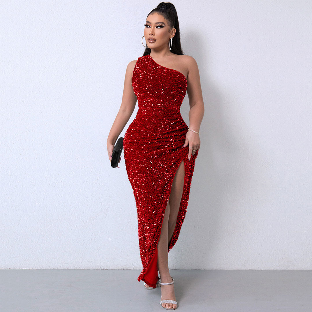 Woman in a red sequined one-shoulder maxi dress with a high slit, holding a clutch.