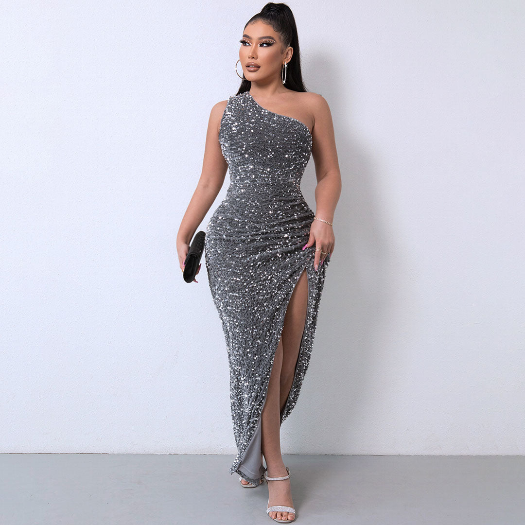 Full-length view of a woman in a sparkling grey sequined dress with a thigh-high slit.