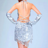 back view of a woman wearing a silver sequin mini dress with fringe detailing and arm warmers
