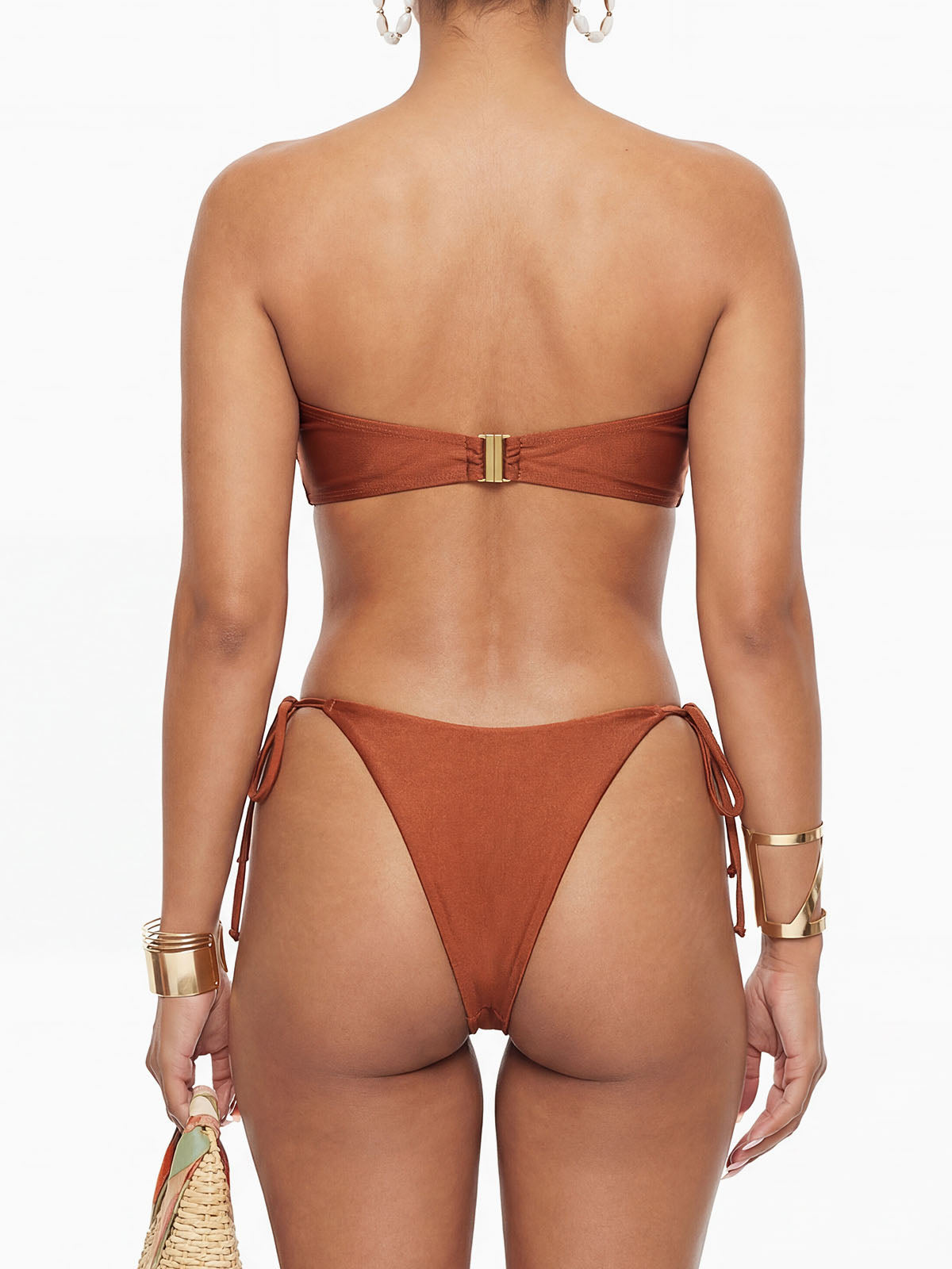 Back view of a woman in a strapless brown bikini with gold hardware