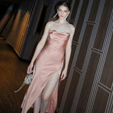 Woman wearing a pink satin slip dress with a high slit and sparkling straps