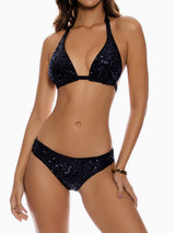 Woman wearing a black sequined halter bikini set
