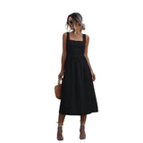 Woman wearing a black sleeveless square neck midi dress with a fitted bodice and A-line skirt.