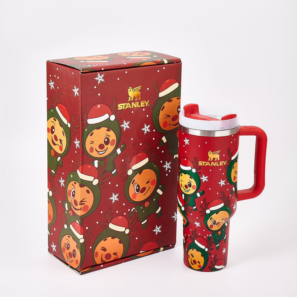 Red Stanley tumbler and matching gift box with holiday reindeer design, angled view