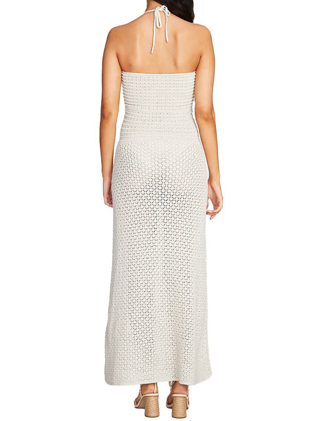 Back view of a woman wearing a white crocheted strapless maxi dress
